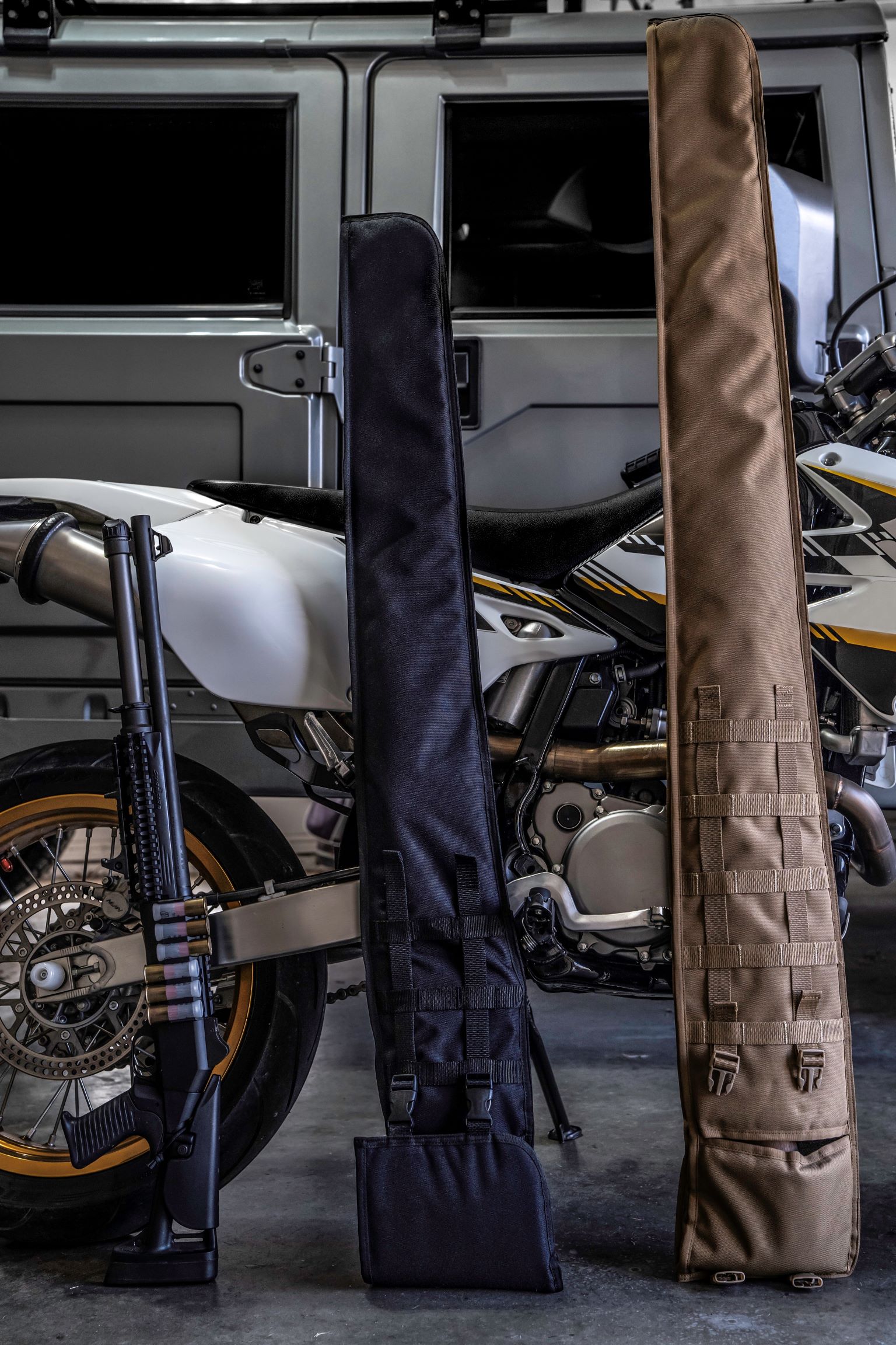 Black and coyote brown shotgun scabbards standing upright against motorcycle.