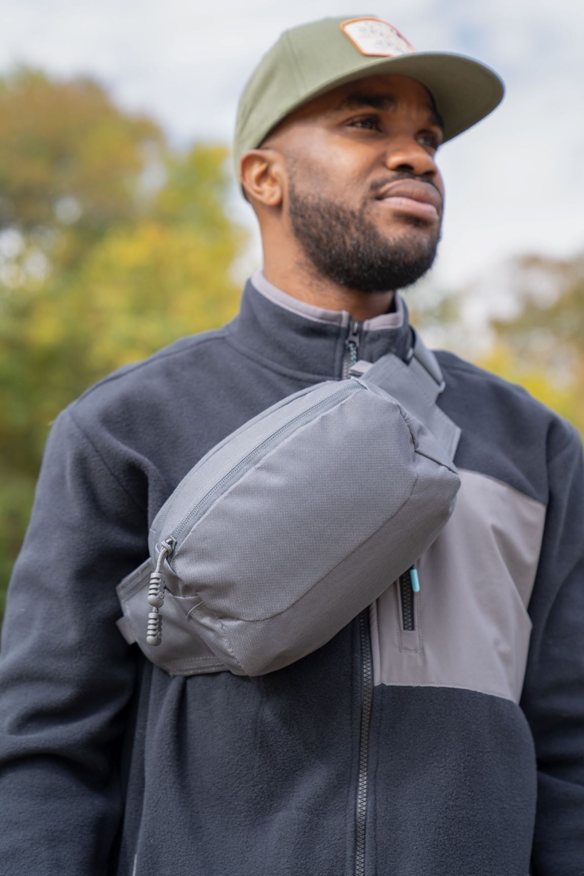 Man wearing gray EDC Sling Bag & Waist Pack across chest.